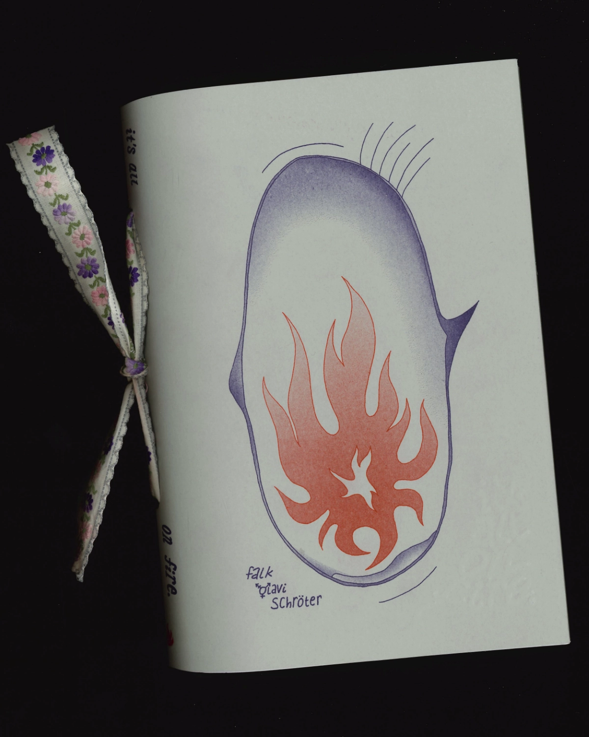 scan of the cover of the book, handbound with a thick ribbon. it depticts an eye tearing up, the iris a flame.