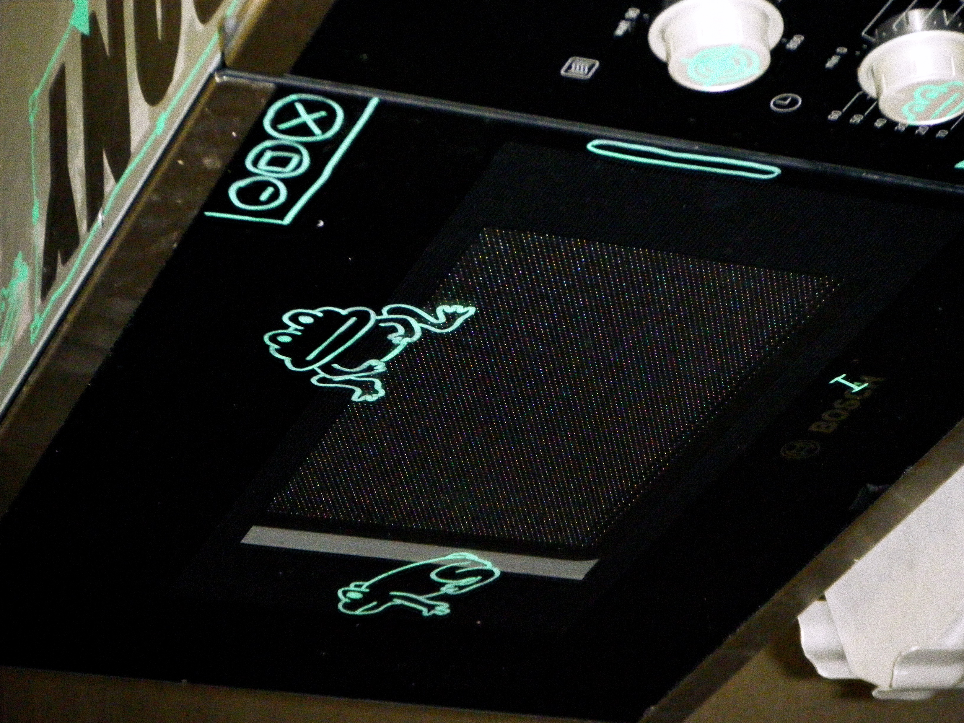the front of the microwave with two frogs drawn on it, as well as parts of a computer interface.